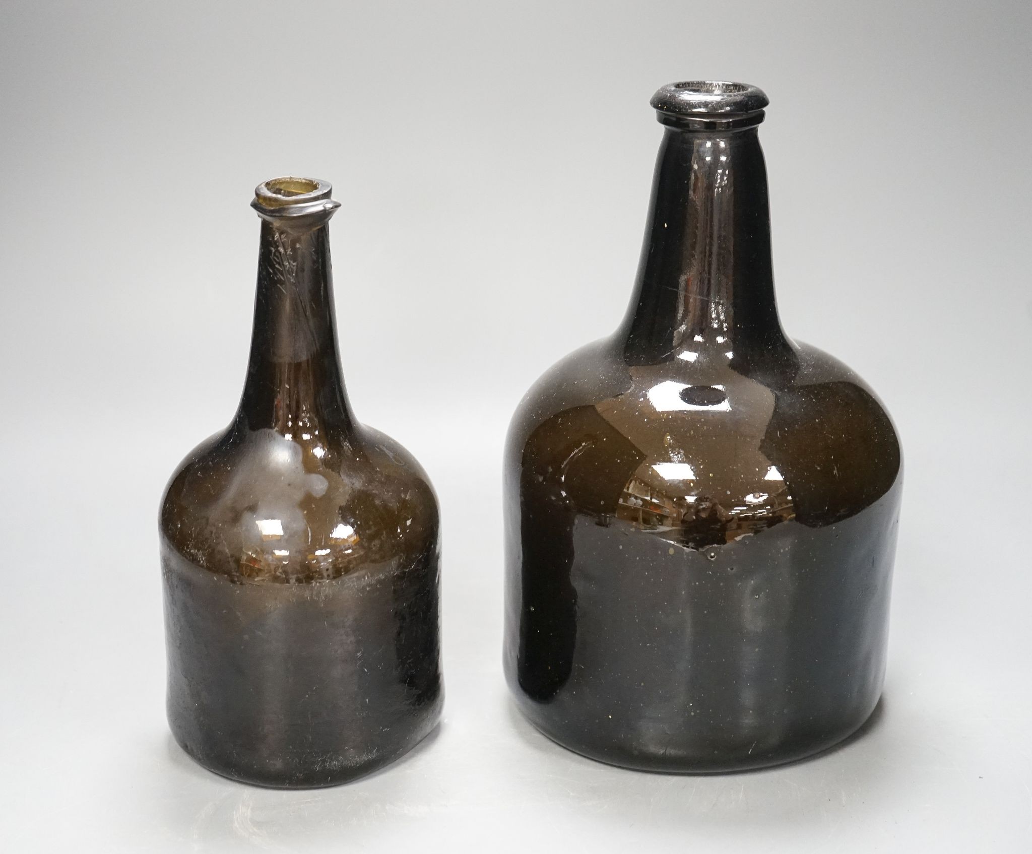 Two mid 18th century glass mallet-shape wine bottles, tallest 27cm